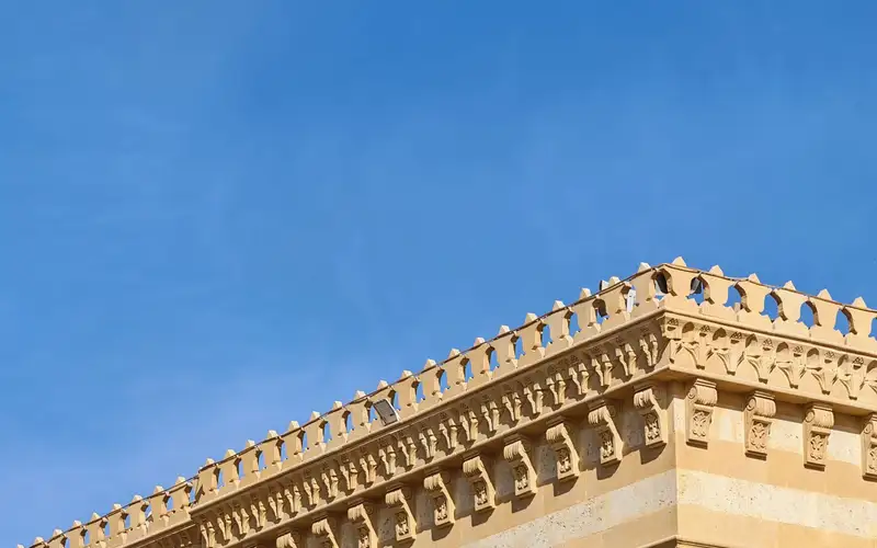 Detalle de una cornisa ornamental de un edificio recortada contra el cielo