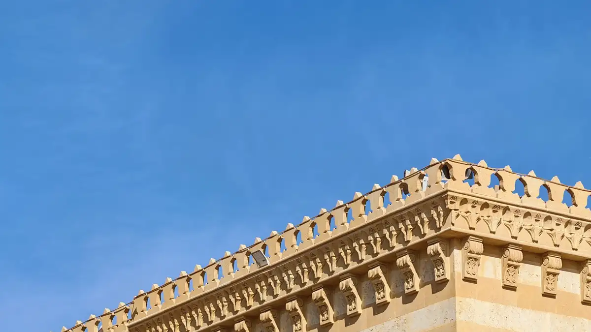 Detalle de una cornisa ornamental de un edificio recortada contra el cielo