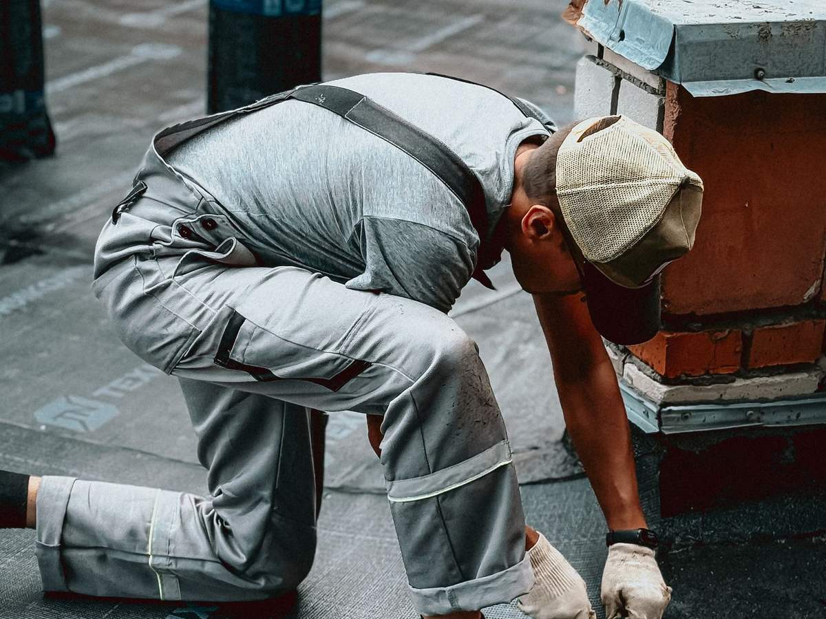 Operario trabajando en una cubierta con la ciudad de fondo