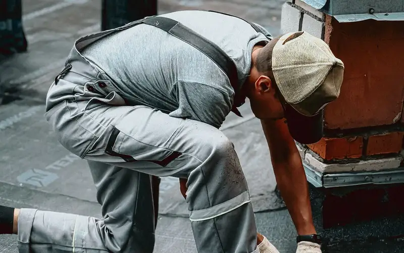 Operario trabajando en la cubierta de un edificio urbano