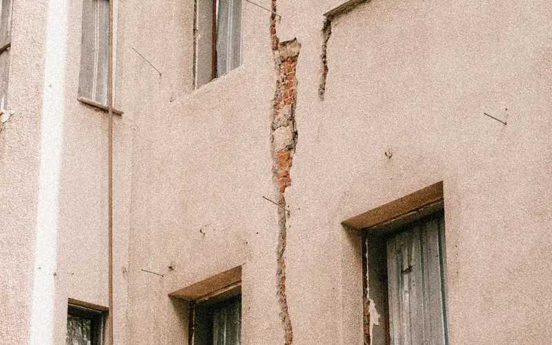 Grietas en el revoco de una fachada alrededor de las ventanas