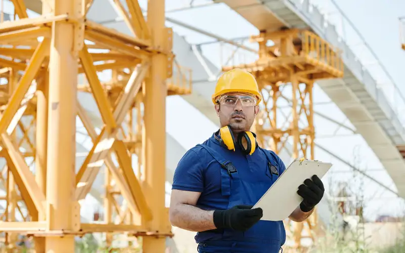 Técnico con casco revisando un informe de inspección en obra