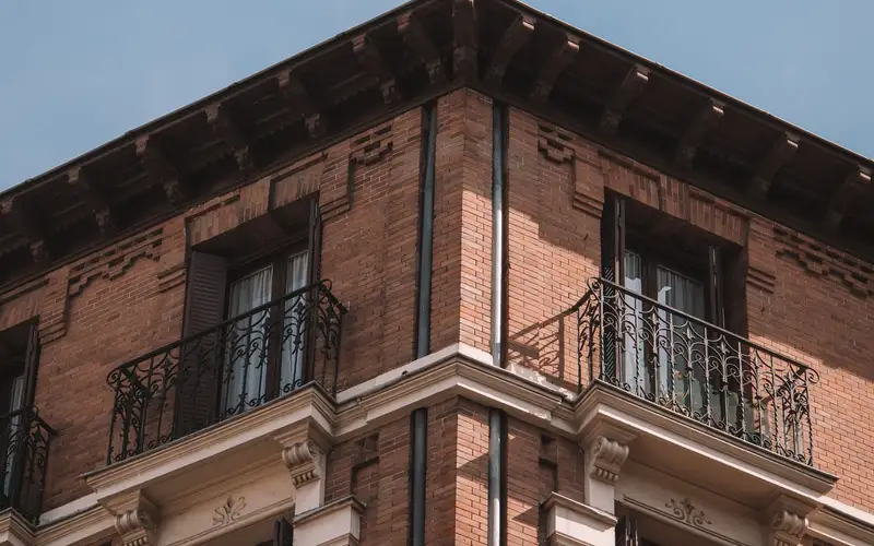 Edificio residencial de ladrillo en Madrid con balcones y ventanas alineados en la fachada