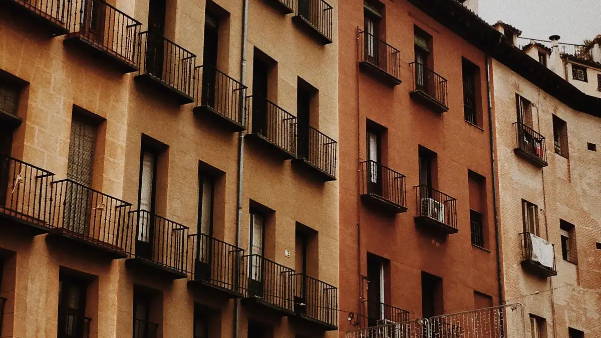 Calle de Madrid con fachadas de ladrillo y balcones en edificios residenciales antiguos