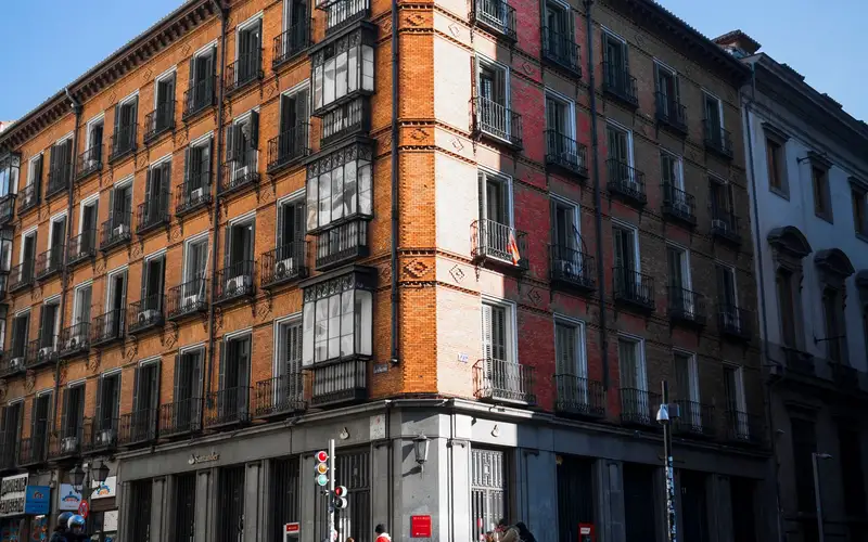 Edificio residencial de Madrid visto desde la esquina, con locales comerciales en la planta baja