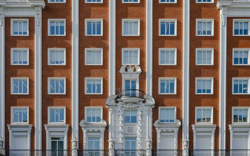 Fachada histórica de Madrid con balcones de forja, molduras y cornisa
