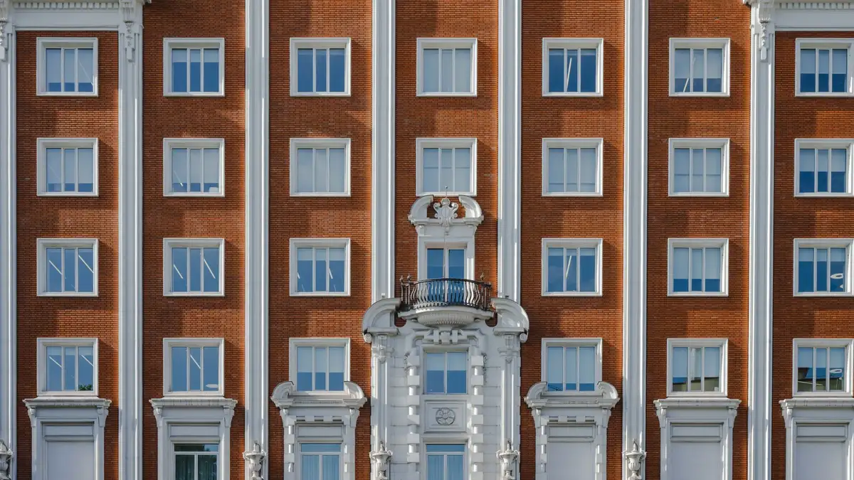 Fachada histórica de Madrid con balcones de forja, molduras y cornisa