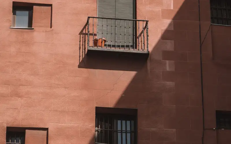 Bloque de viviendas de ladrillo visto con balcones, típico de los barrios de Madrid de los años sesenta a noventa