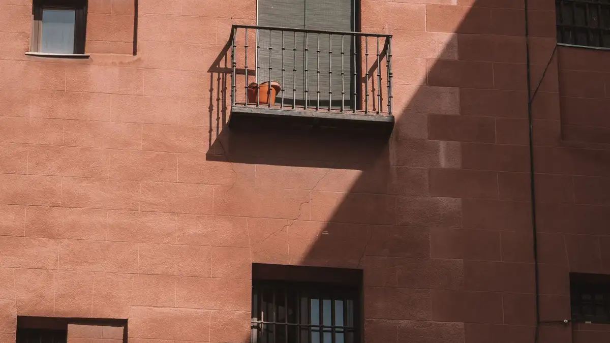 Bloque de viviendas de ladrillo visto con balcones, típico de los barrios de Madrid de los años sesenta a noventa