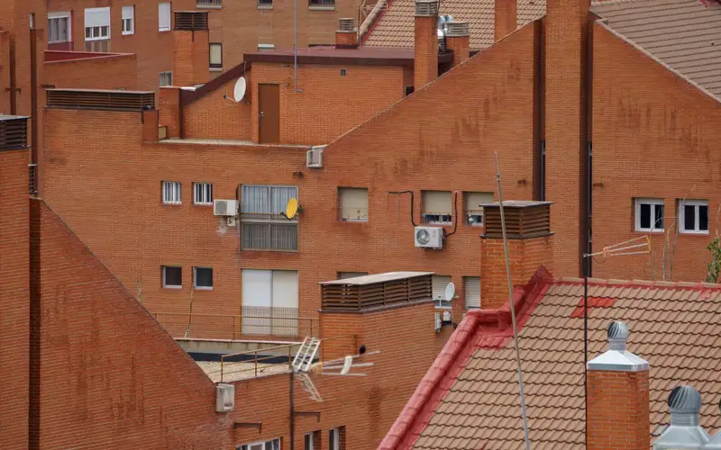 Tejados de teja cerámica curva de edificios residenciales de Madrid, con chimeneas y buhardillas