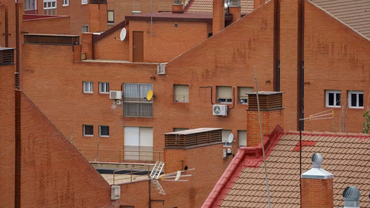 Tejados de teja cerámica curva de edificios residenciales de Madrid, con chimeneas y buhardillas